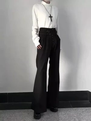 Gothic high-waisted black flare trousers front full-body view demonstrating structured silhouette and wide leg drape, coordinated with white turtleneck and cross pendant for elegant contrast