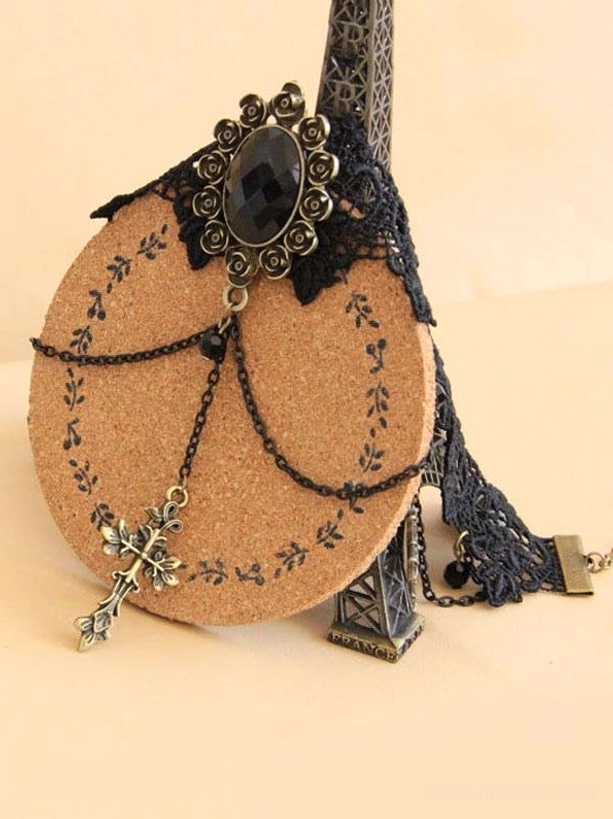 black gothic lace choker styled display with eiffel tower miniature decor showing black lace neckband oval gem ornament and bronze cross pendants