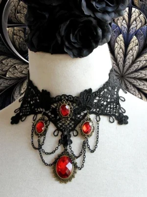 Black gothic lace choker necklace with red gemstone accents and antique metal chain displayed on mannequin with black floral headpiece front overhead view