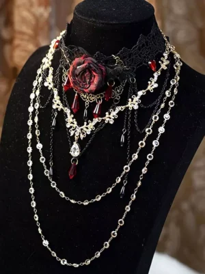 Gothic layered black lace rose choker necklace with crimson red crystal pendants and dual-tone metal chains, displayed on black mannequin neck showing full front view and detailed pendant design