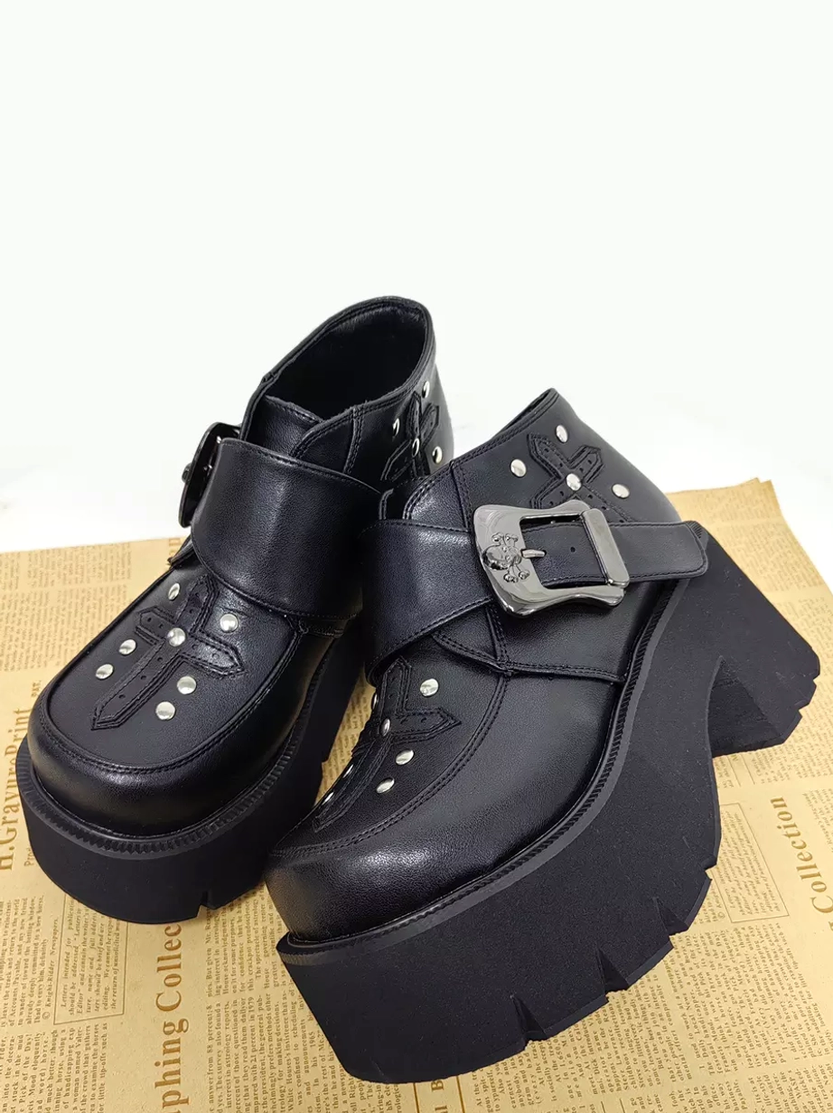 Low-angle front view of gothic lolita ankle boots showing jagged sole edge, silver metal hardware, and chunky heel construction detail