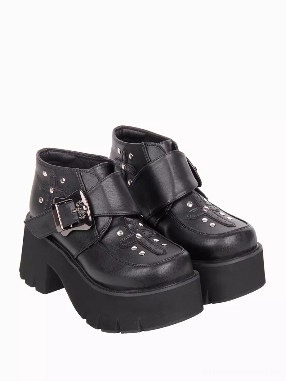 Side view of gothic lolita ankle boots displaying skull belt buckle, metal studs, and thick platform sole with jagged edge detailing