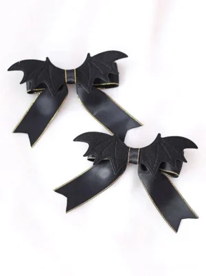 Gothic lolita bat wing bow hair clips all-black satin with gold metallic trim and faux leather bat wing accents flat lay top view