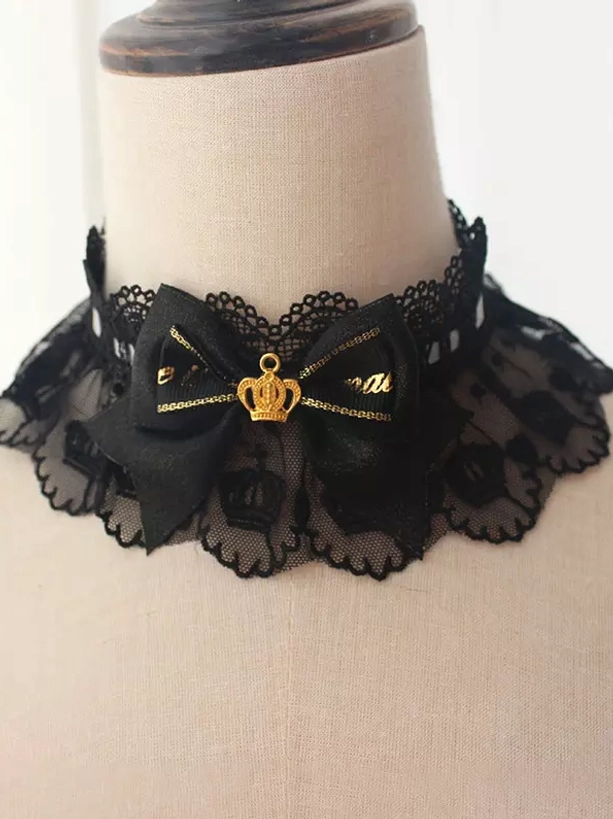 Gothic lolita black lace choker featuring large ornate gold crown charm and black decorative bow detailed close-up