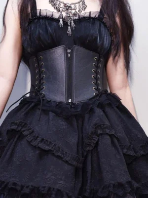 Gothic Lolita black corset belt with dual lace-up sides worn on female model showing front half-body view with ruffled layered skirt and vintage silver necklace