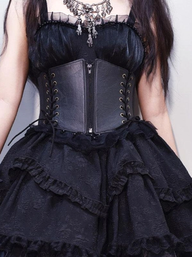 Gothic Lolita black corset belt with dual lace-up sides worn on female model showing front half-body view with ruffled layered skirt and vintage silver necklace