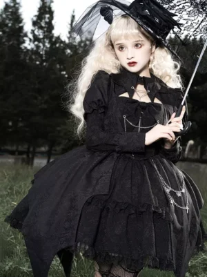 Gothic lolita black dress with chain ornaments and puffed sleeves, three-quarter front view with lace umbrella and veil headwear accessory
