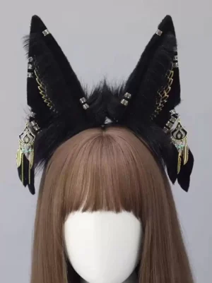 Decorative black fox ear headband with gold wing patterns, rhinestone fasteners and vintage metal pendants on wig mannequin with brown bangs, gothic style lolita headdress detail shot