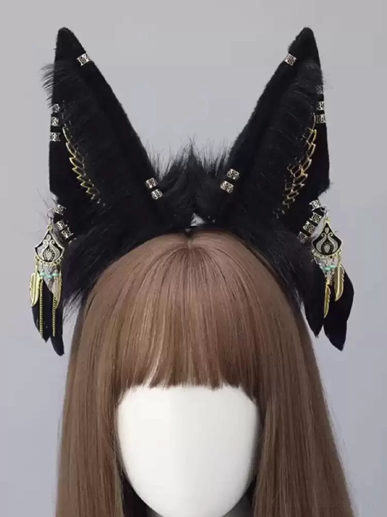 Decorative black fox ear headband with gold wing patterns, rhinestone fasteners and vintage metal pendants on wig mannequin with brown bangs, gothic style lolita headdress detail shot