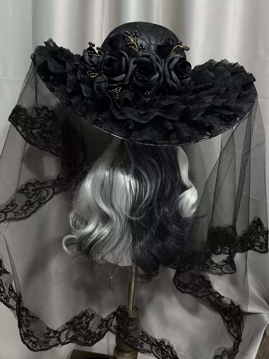 Black gothic lolita wide-brimmed hat with black roses and bead decorations on brim, front three-quarter view with gradient hair mannequin