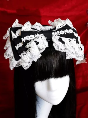 Gothic Lolita black lace bow hair accessory with embroidered white ruffles, front close-up view on mannequin with straight black bangs