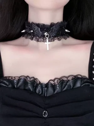 Gothic lolita black lace choker with metal spikes and winged cross pendant worn on model, front upper neck close-up view, featuring ruffled lace texture and detailed metalwork