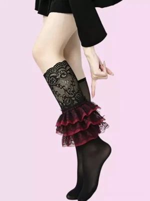 Black floral lace ruffle calf socks with wine red tiered trim worn on model's leg in black Mary Jane heels and black dress against pink background Lolita Gothic fashion hosiery