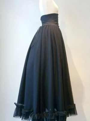 Black Gothic Lolita lace-up skirt side profile view showing hidden pocket detail, matte waistband, and architectural tulle ruffled hem structure