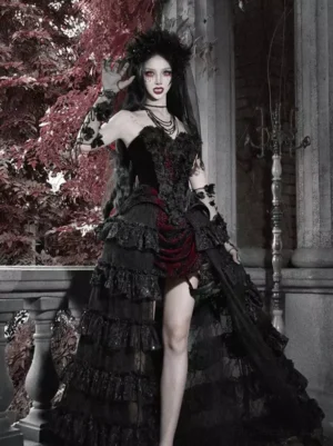 Black and red gothic lolita tiered skirt with dramatic train, full front view on model in dark gothic styling with vintage terrace backdrop, high-waisted design with lace ruffled layers