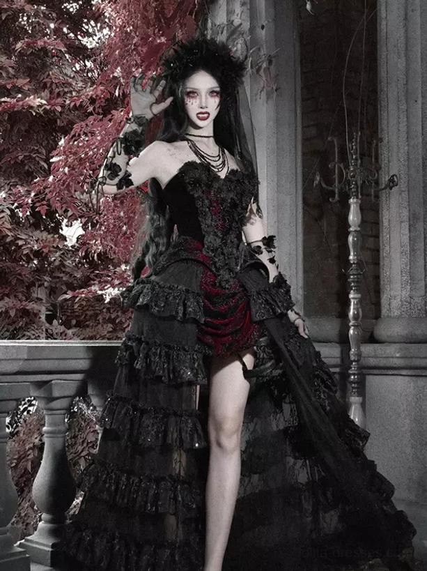 Black and red gothic lolita tiered skirt with dramatic train, full front view on model in dark gothic styling with vintage terrace backdrop, high-waisted design with lace ruffled layers