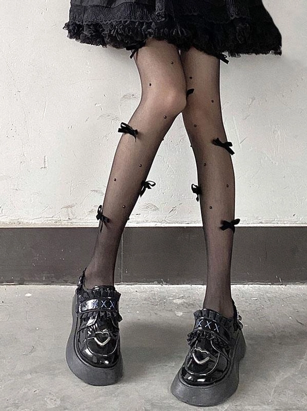 Gothic lolita sheer tights side leg view black satin bows scattered dot details sheer black fabric black ruffled skirt platform shoes