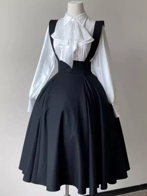 Black Gothic Lolita suspender skirt front mannequin display with high-waisted flared midi silhouette and wide shoulder straps paired with white ruffled bow blouse