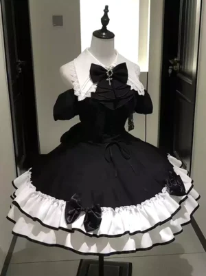 Black white gothic lolita dress front angle view on dress form displaying lace collar and cross-decorated front bow embellishment detail