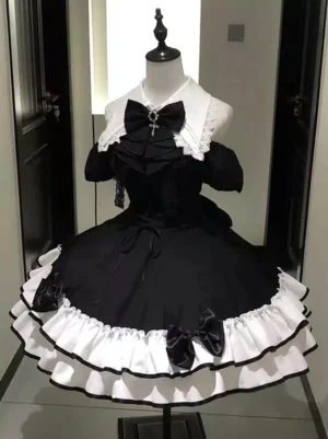 Black and white off-shoulder gothic lolita dress with tiered ruffles displayed on mannequin, front full-length view showing dramatic ruffle tiers and cross-bow accent