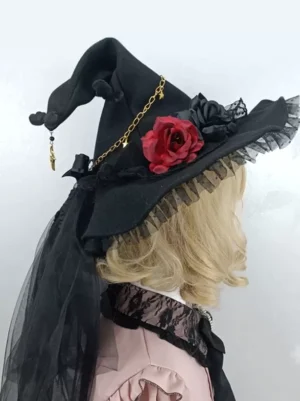 Gothic Lolita black witch hat with ruffled mesh brim, red rose decoration, and gold chain pendant, displayed on mannequin in pink lolita top from right rear side angle showing intricate details and black tulle veil