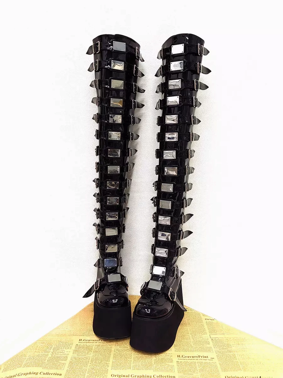Front view of over-the-knee gothic platform lolita boots highlighting square silver metal trims and rectangular buckles along the shaft with thick matte wedge sole