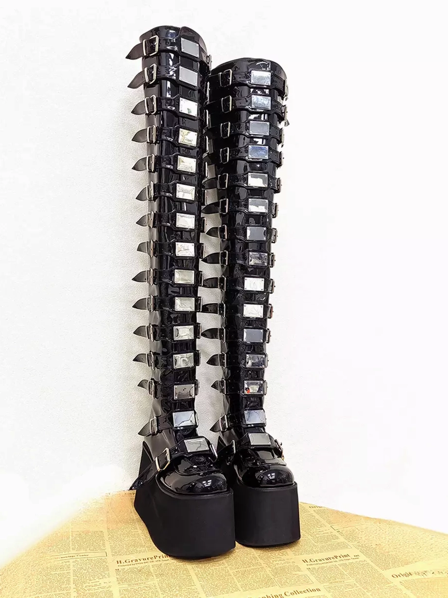 Front outer side view of over-the-knee gothic lolita platform boots showing dense silver buckles and metal trims with thick matte wedge sole base