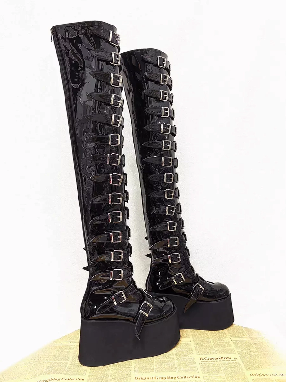 Pair of glossy black gothic lolita platform boots three-quarter side view displaying matching silver buckle designs on both boots and thick platform sole