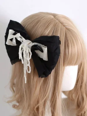 Gothic lolita bow hair clip side back view worn on mannequin with light brown bangs, showcasing dual-tone large bow design and hanging pearl tassel pendant from multiple angles