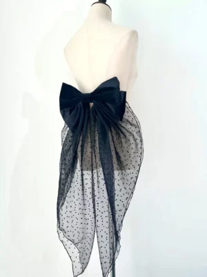 Gothic lolita detachable bow tail accessory back angle view displayed on dress form showing rear of black velvet bow and flowing polka-dot mesh train