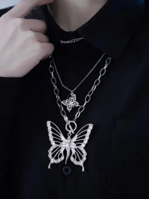 Gothic Lolita layered butterfly pendant necklace worn on model with black collar shirt, vintage silver tone hollow carved butterflies, front upper body fashion photography