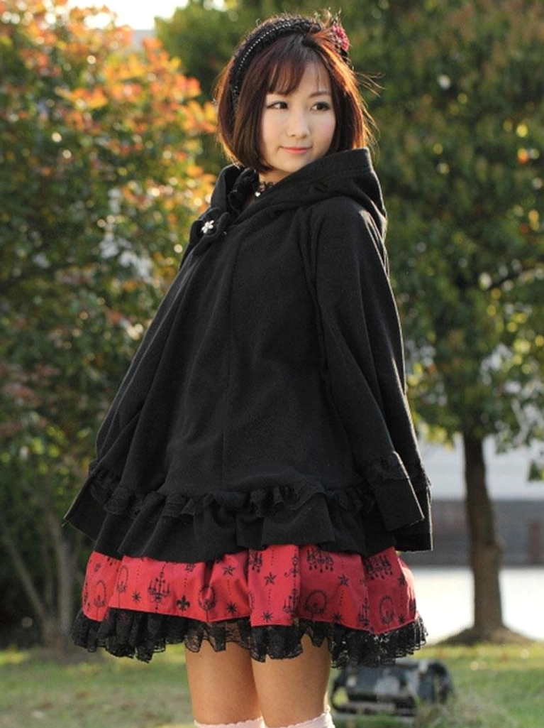 Right side medium shot of gothic lolita hooded cape coat with hood down and ruffled cuffs paired with red lolita skirt