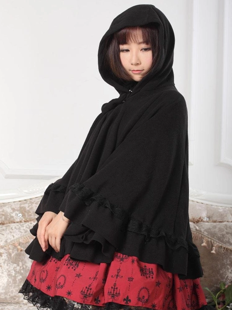 Left side profile of black gothic lolita cape coat with hood up displaying ruffled sleeve trim and loose flowing fabric