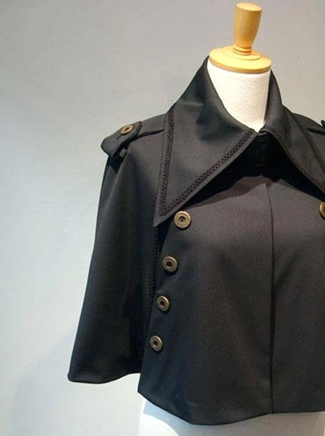 Close-up detail view of Gothic Lolita cape showing tailored collar with decorative topstitching, shoulder tab buttons, cropped fit length, and premium construction details on dress mannequin