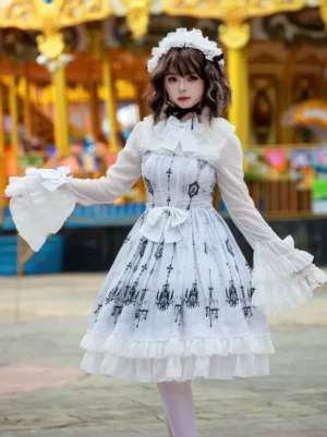 White gothic lolita dress with black chandelier print and ruffled long sleeves, front full-body view in amusement park carousel setting