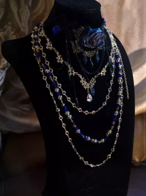 Vintage multi-layer black lace Gothic choker necklace with blue floral ornament and teardrop crystal pendant, front view on mannequin