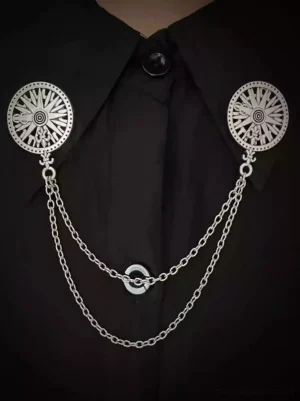 Gothic lolita dual compass collar chain brooch worn on black formal shirt collar, silver metal double pendants with linked chains, close-up front view of Victorian-inspired accessory on formal neckline