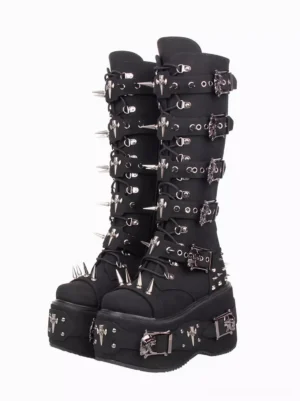 Black gothic lolita corduroy platform boots with metallic spike grommets and decorative skull buckles, front oblique view showing round toe and thick platform sole