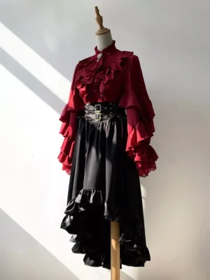 Gothic lolita asymmetric ruffle skirt with corset waistband and metal buckles worn on dress form with dramatic lighting showcasing the high-low hemline and layered satin ruffles