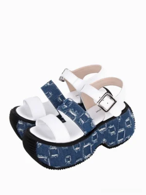 Gothic Lolita denim platform sandal front three-quarter view, single shoe with white textile strap, blue distressed denim platform sole, black outsole, silver adjustable buckle closure