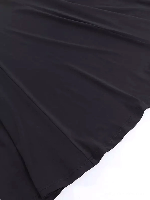 Fabric texture close-up of gothic lolita dress showing soft drapey black stretch polyester material and hem details