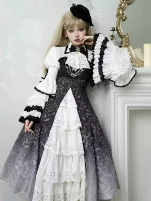 Black and white Gothic Lolita jumper dress with lace floral print shown on model wearing black hair ornament in three-quarter front view with fireplace backdrop, featuring layered lace skirt and ruffled sleeves