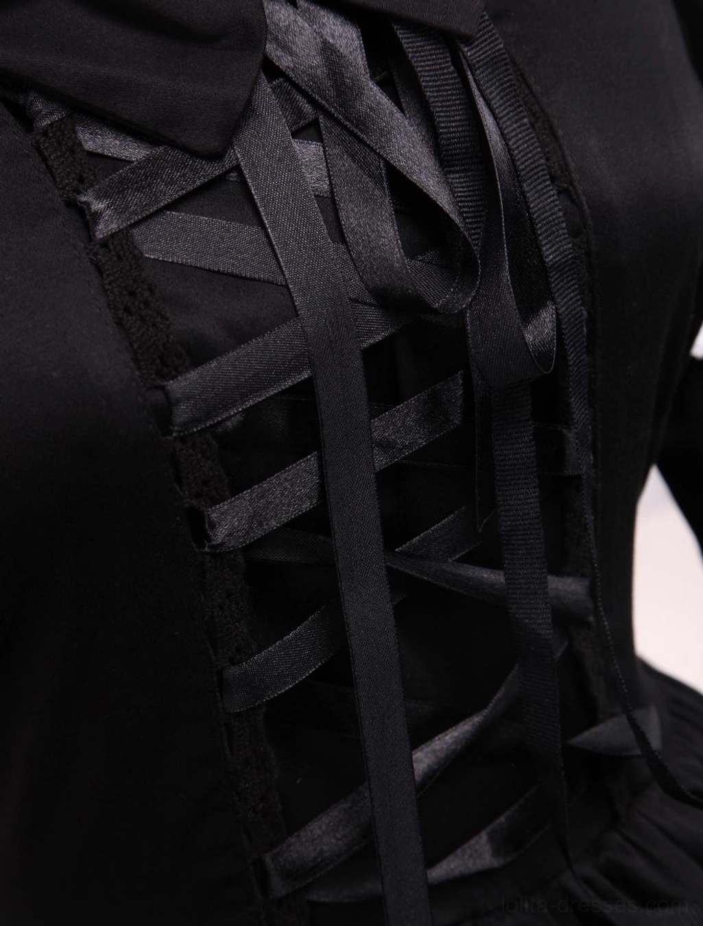Close-up of black Gothic Lolita dress bodice showing ribbon lace-up closure front and matte black satin fabric texture