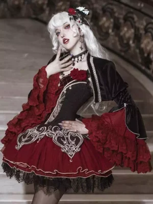 Burgundy and black gothic lolita dress with embroidered rose details and mesh ruffled sleeves worn on model in three-quarter view on vintage staircase