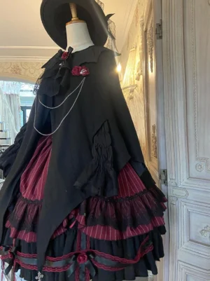 Gothic Lolita dress and cape ensemble front flat display featuring black wine red color layered ruffle skirt rose brooch and chain trim