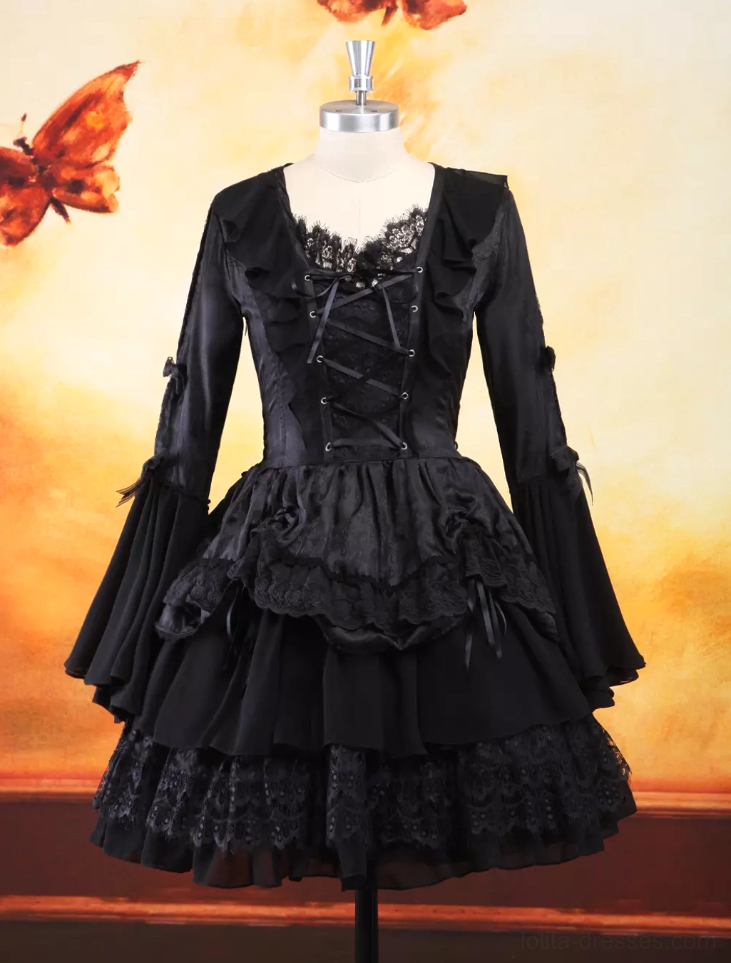 Dress form display of gothic lolita one-piece dress featuring detailed lace neckline, front lace-up closure, decorative sleeve bows, and intricate lace trim