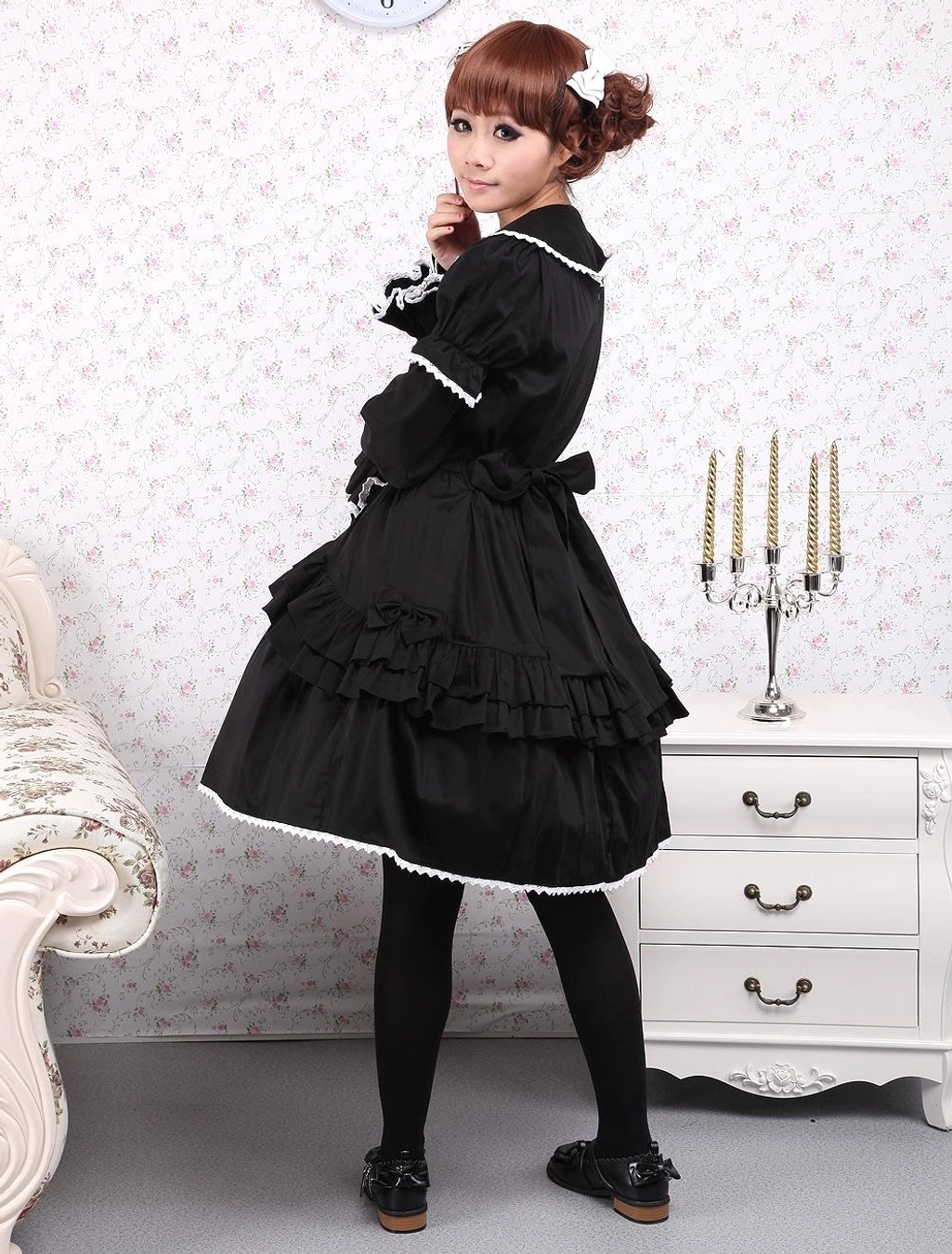 Side body view of model wearing black cotton Gothic Lolita dress showcasing dramatic layered ruffled skirt design and silhouette