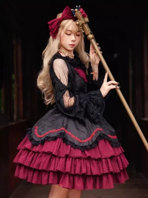Gothic lolita jumper dress close-up detail view showing velvet bow with pearl waist decoration, ruffled neck trim, and textured jacquard bodice on model