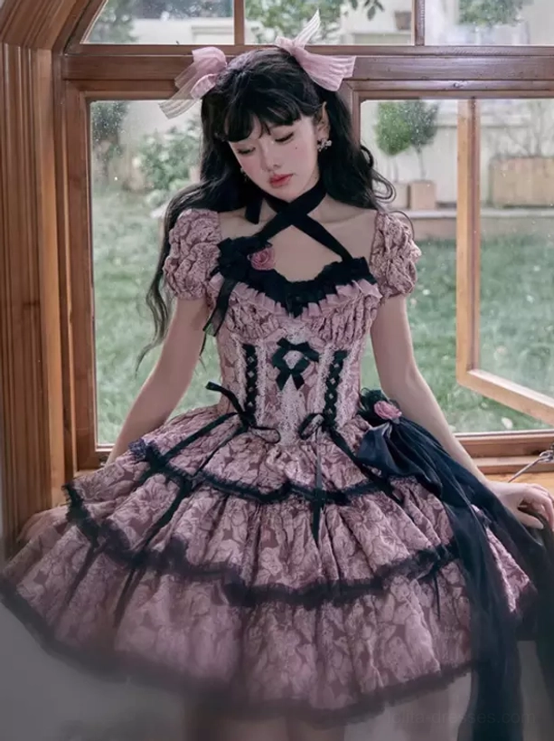 Gothic Lolita dress with cross halter neckline, floral print pattern, black lace trims, and decorative head bow accessory, model in window indoor setting