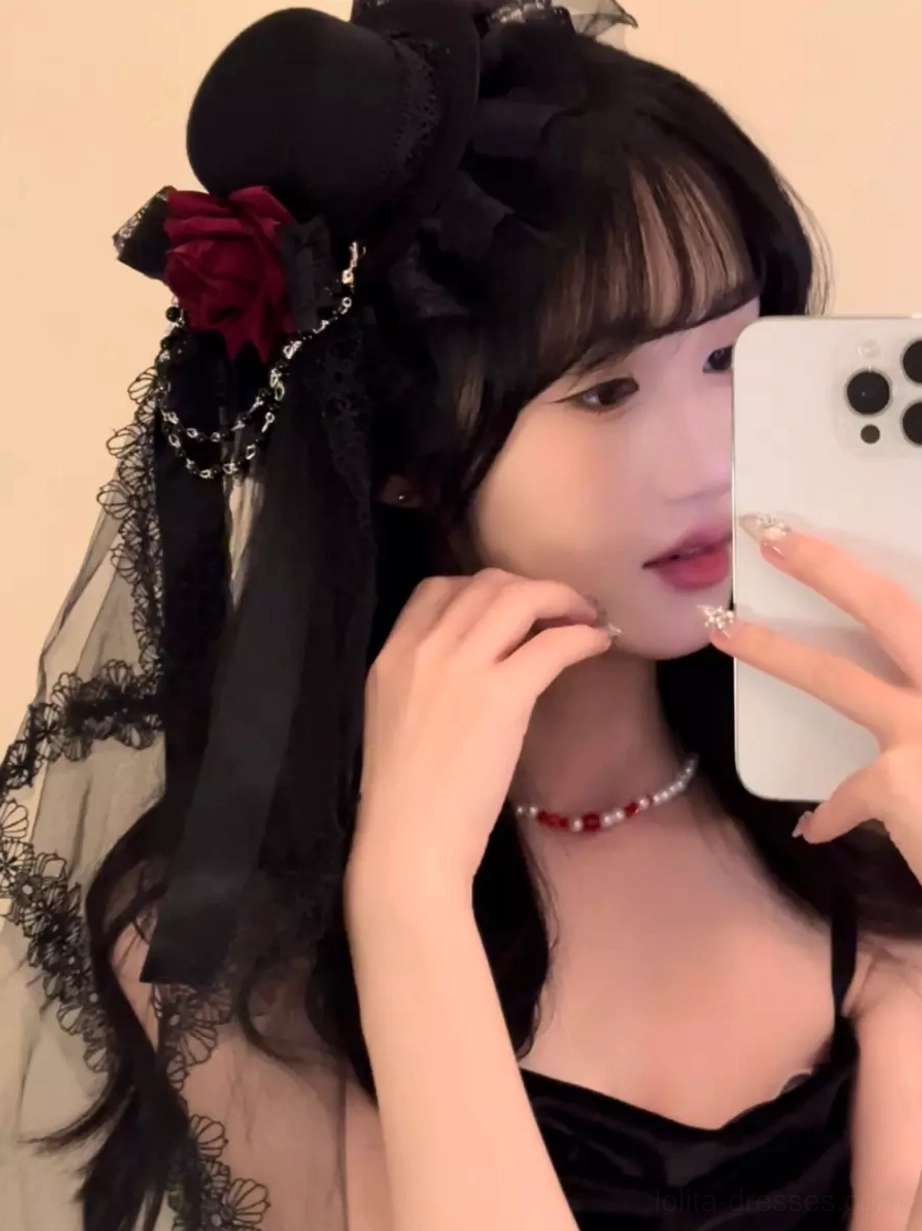 Half-face selfie view of Gothic Lolita hair accessory with black lace veil, red rose embellishment, and silver chain on model with long black hair